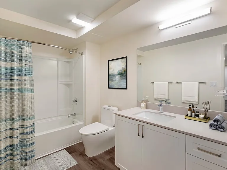 Bath with beige quartz countertops, white cabinetry, and hard surface flooring (Select Home)