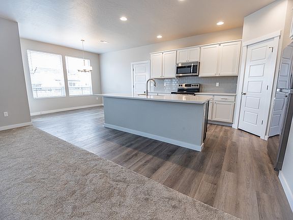 Spacious kitchen with center island, stainless appliances, pantry and dining area.
