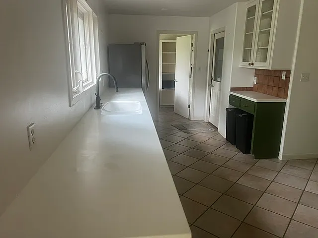 Kitchen with new corian counter tops and lots of counter space. Door to the back right leads to garage. Door in the back leds to washer dryer and pantry area.