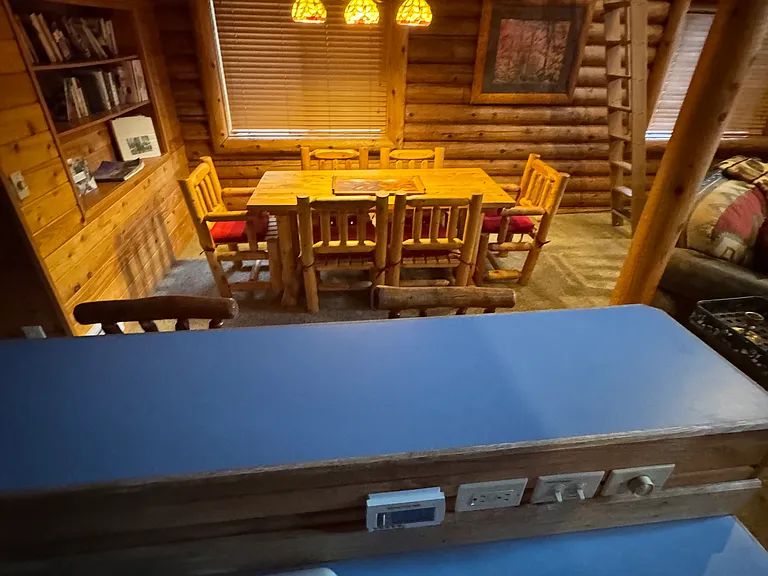 Open layout kitchen with bar stools and nearby dining table.
