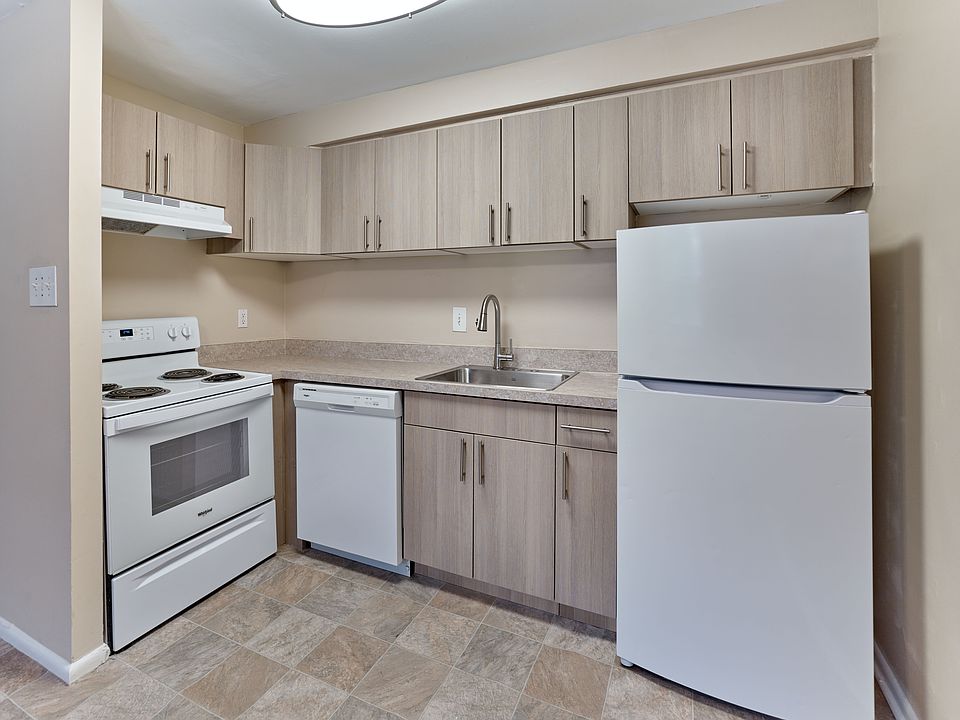 Spacious updated kitchen featuring sleek white appliances, wood-tone cabinetry, and a modern layout at Maple Terrace Apartments in Maple Shade, NJ.