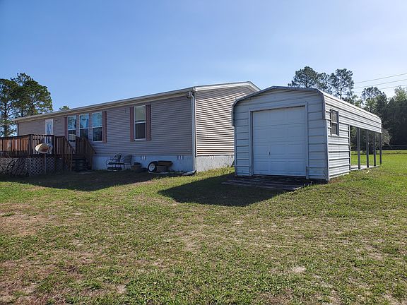 Back view with new 8ft by 14ft patio and carport with storage