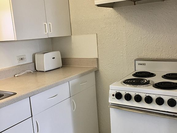 Four-burner stove with fan above. (Toaster not included)