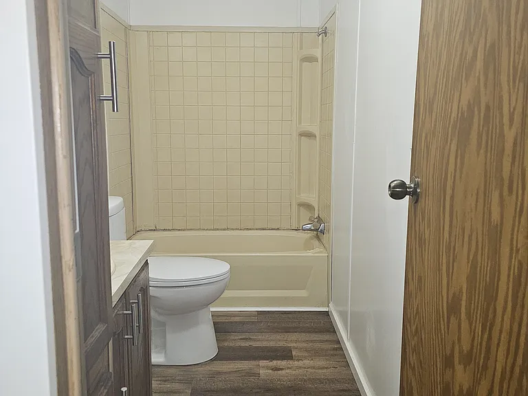Hall bathroom with brand new toilet, new vinyl plank flooring, new trim, and freshly painted.