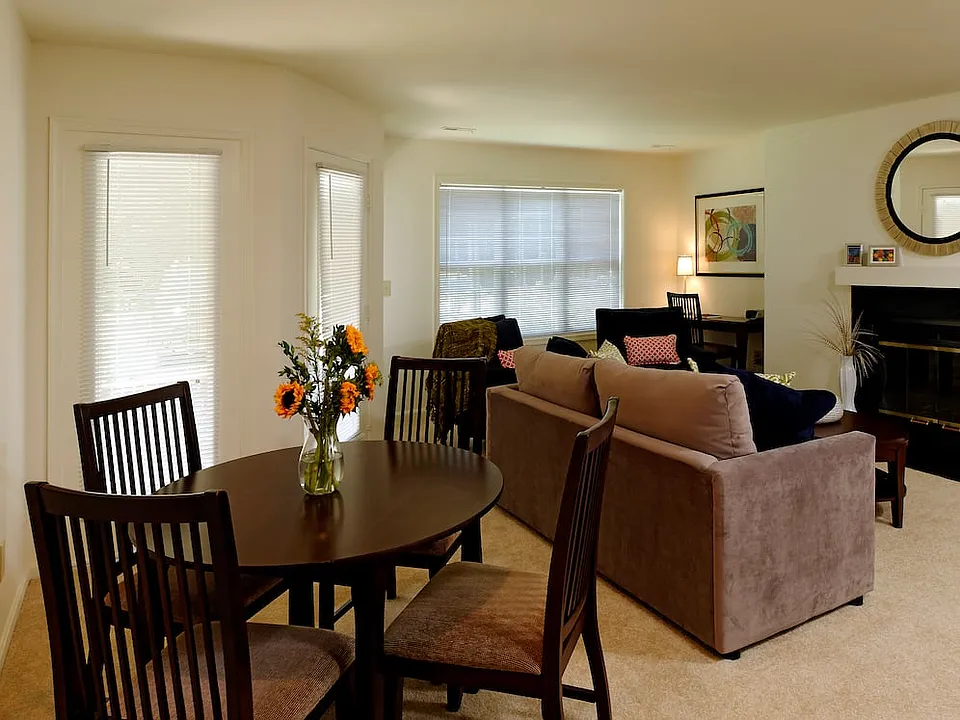 Carpeted dining and living area with fireplace
