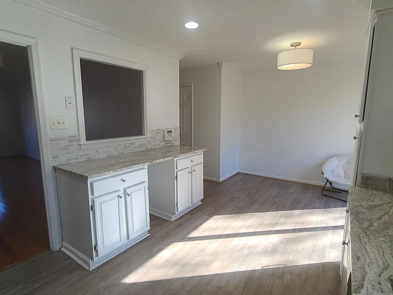 View from cozy sun-lit kitchen into main living space (facing bay window)
