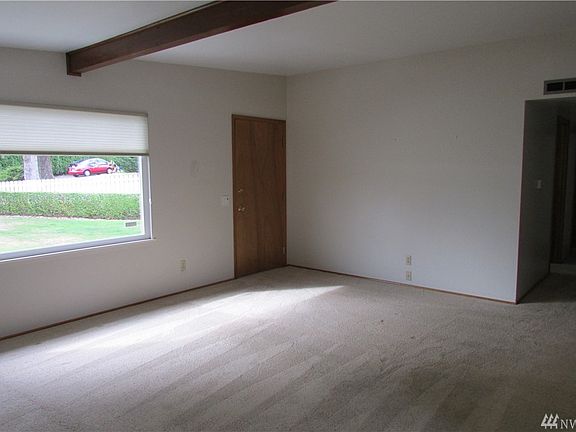 Livingroom with Hunter Douglas blinds, large window lets in lots of light & freshly cleaned carpet.