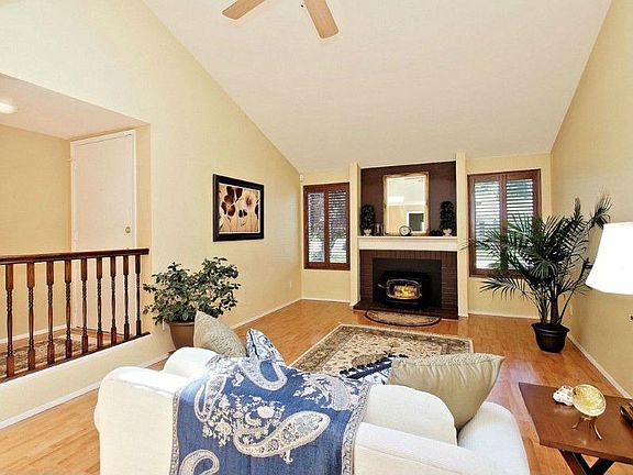 ENTER THE SUNNY LIVING ROOM WITH WOOD FLOORING AND WOOD BURNING FIREPLACE INSERT WITH THE ADDED TOUC