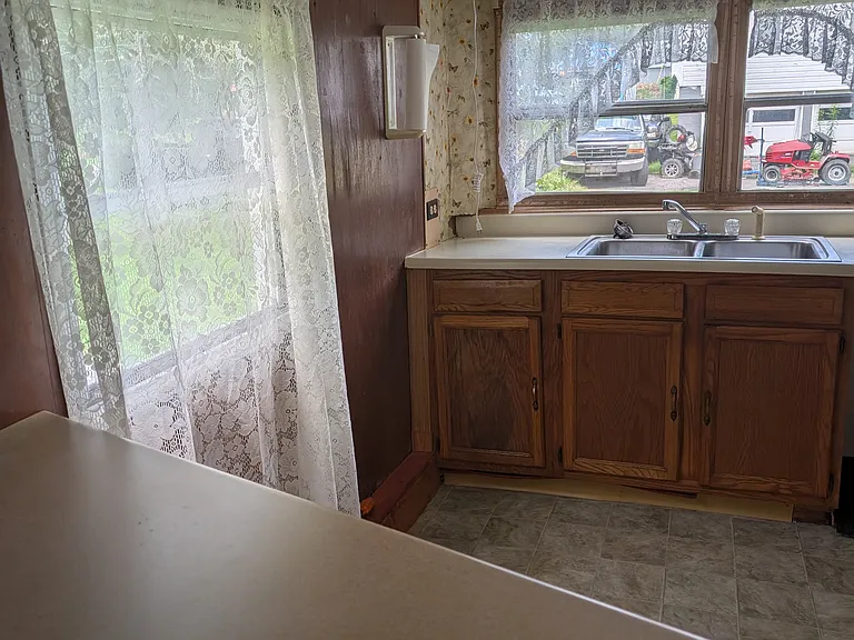Kitchen island in foreground, lots of natural light in kitchen.