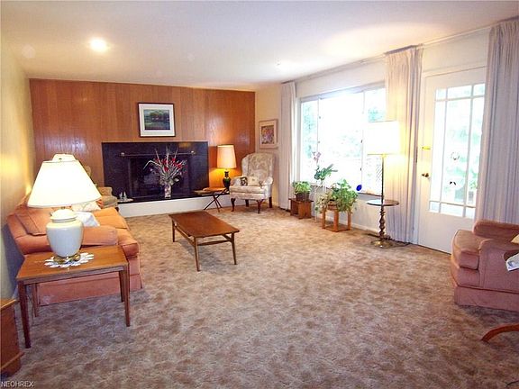 Open Living Room with hardwood floors under carpet.  Large window overlooks private backyard.