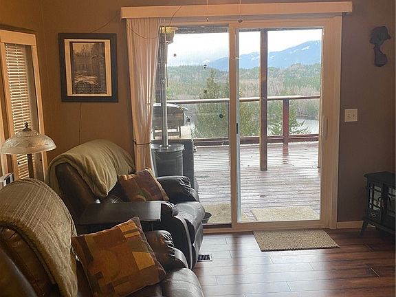 Living area with laminate floors and slider to back deck space. 