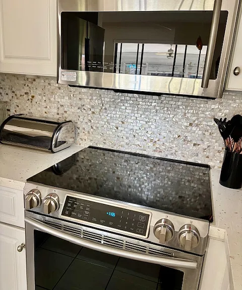 Samsung Induction Stovetop, oven, and Microwave set - Cool to the touch stove top even when cooking! Mother of pearl back splash throughout kitchen