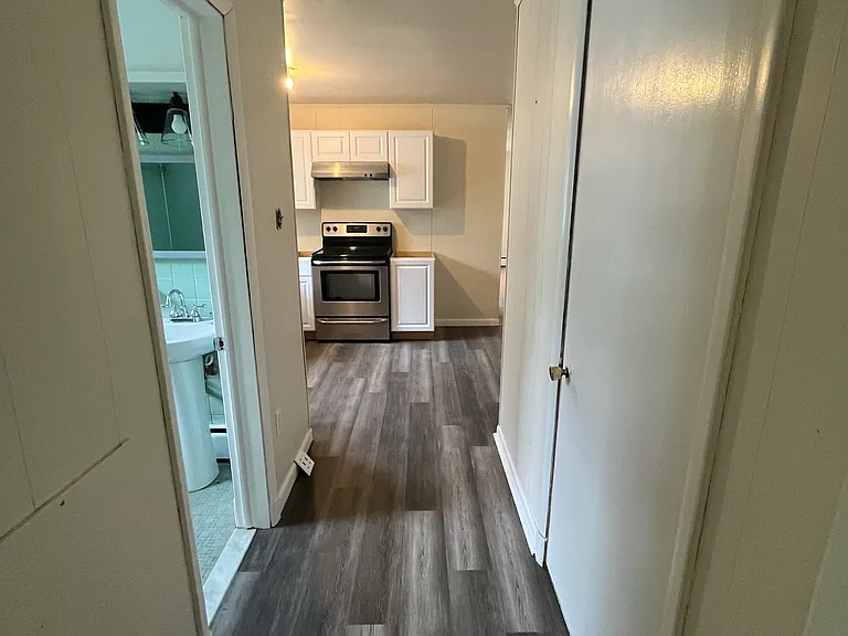 Hallway from bedroom to kitchen (bath on left, utility closet with washer/dryer on right)
