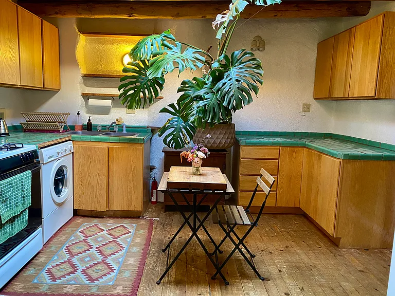 Gas stove, full size refrigerator, plenty of storage, and the washing machine are located in this bright kitchen.