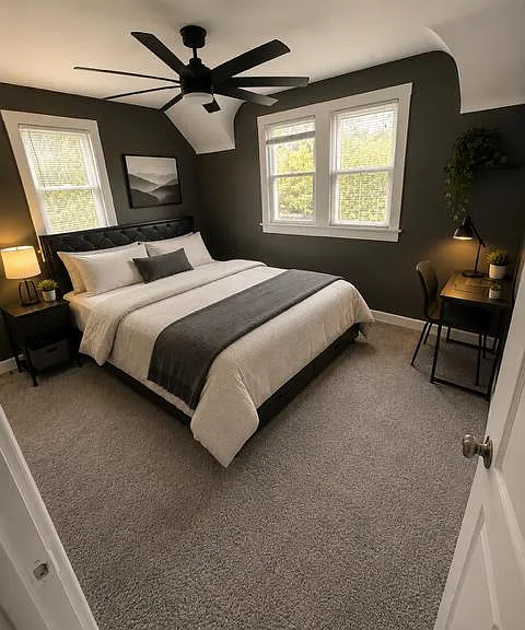 Bedroom with a full/queen bed, two windows, ceiling fan, nightstand, and a compact desk setup for work or study.