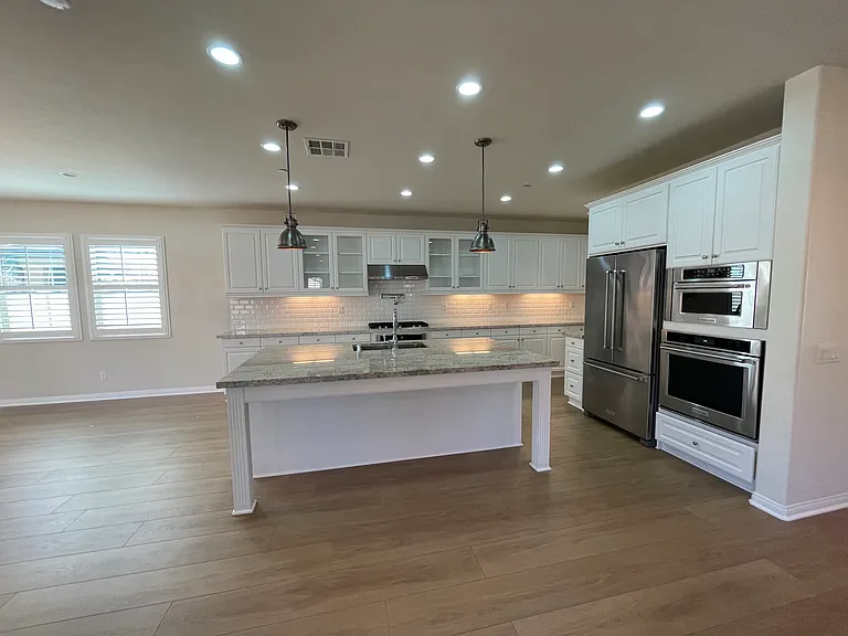 Kitchen w/ upgraded KitchenAide appliances, granite countertops and plentry of cabinetry.