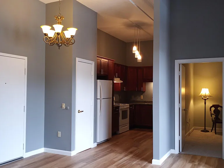 Entry to main living area in apartment. Kitchen to left. Bedroom also on left.