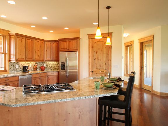 Large open kitchen features granite countertops, upgraded stainless applicances, eating bar and walk