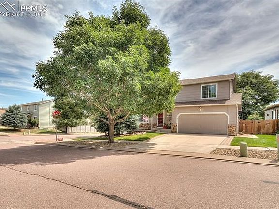 Large Corner lot with manicured lawn and tiered landscape on the side of the home.