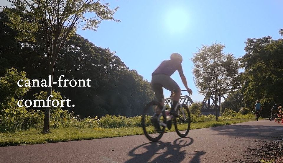 A person riding a bicycle on the Erie Canal path near Westport Crossing in Pittsford, NY