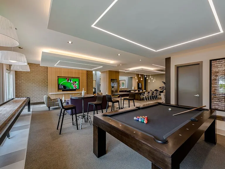 Resident lounge with shuffleboard and billiards, flat screen televisions, entertaining kitchen and seating