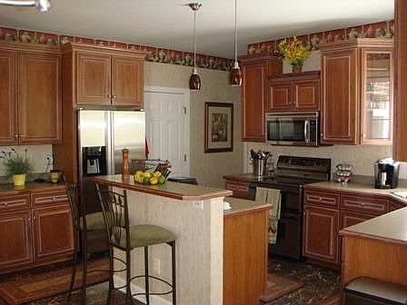 Chef's kitchen w/ marble flooring, new faucet, SS appl, pecan glazed cabinets.