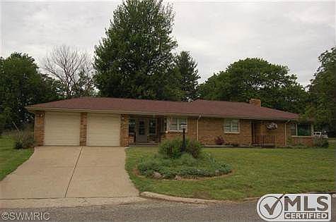 Front view of brick ranch sitting on a large corner lot.