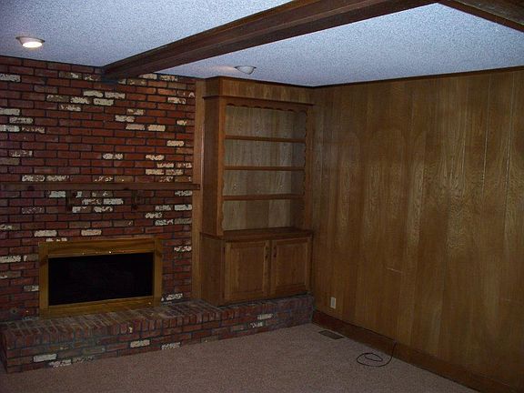 Den with fireplace. Paneling is painted now.