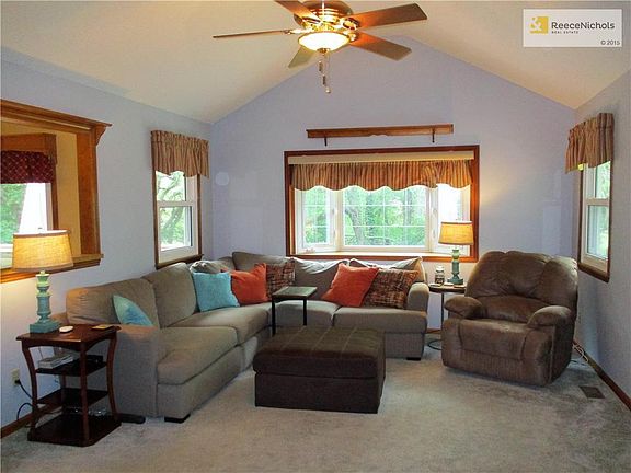 The large, light-filled great room features a bay window, vaulted ceiling and fan.