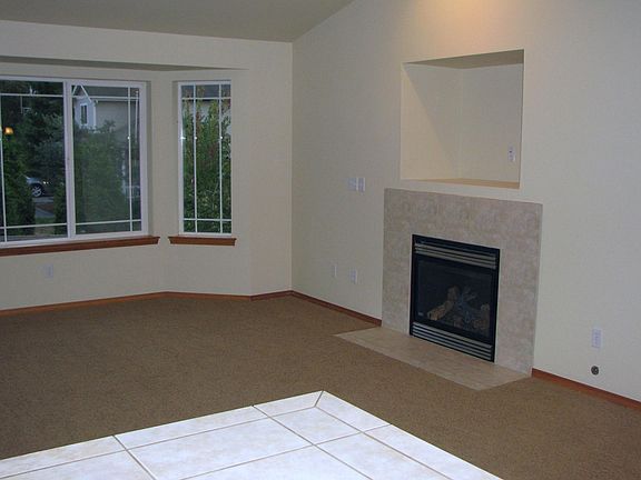 Great Room next to kitchen has bay windows and a cozy gas fi