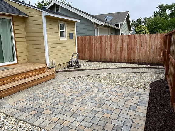 From the side gate. Back patio, redwood deck, a peek at the slider. 
No plants in this image.