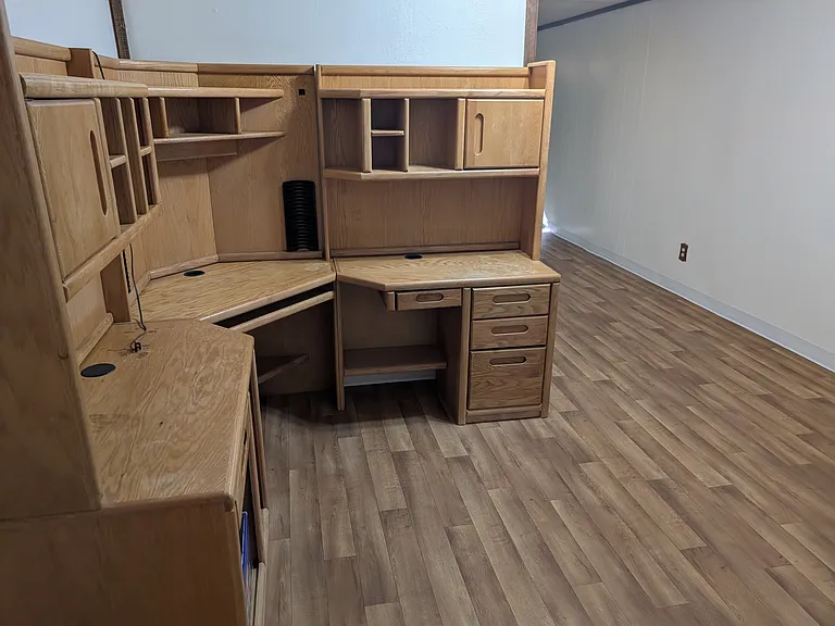 large desk across from built in shelves in the basement