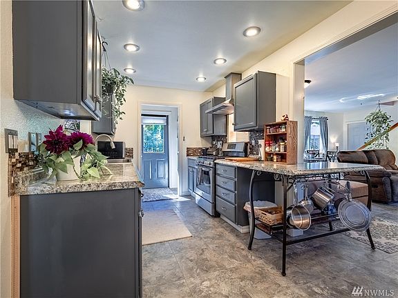 In the rear of the kitchen there's a pantry and then door leading to the beautiful deck, hot tub, and garden paths.