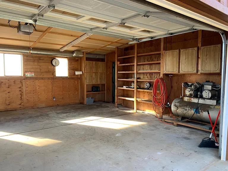 Heated double garage with huge compressor that is plumbed to all garages, auto & wood shop