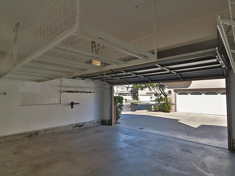 Attached two car garage with massive overhead storage and lot of addition shelf space for holiday supplies and sport equipment.