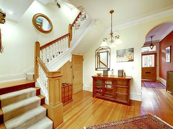 Grand foyer with another fireplace and original woodwork 