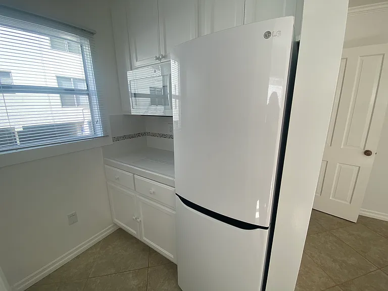 Kitchen area with large refrigerator and microwave.