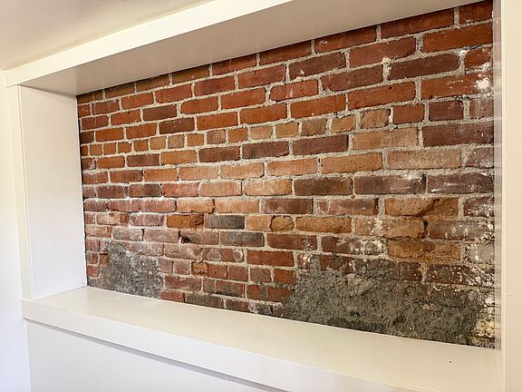Exposed brick cubby in the foyer. This is a great place to keep dog leashes, grocery bags, etc... There are hooks for hanging coats and umbrellas. This room makes a good mud room.
