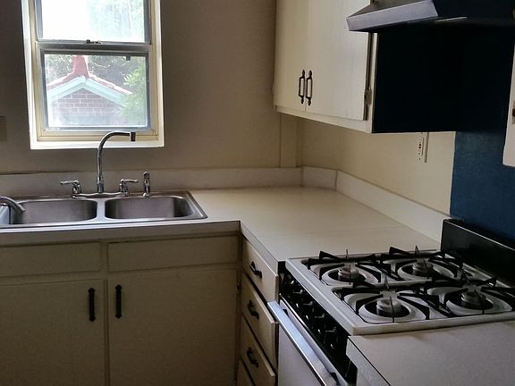 the kitchen has a double sink and a gas range.