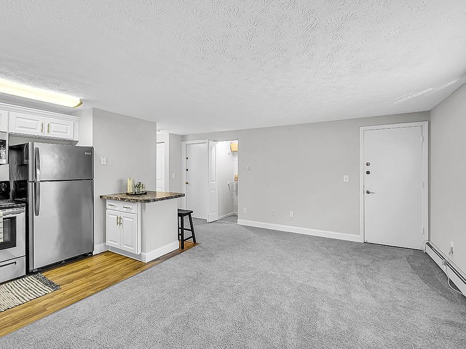 The kitchen layout in The Willow floor plan features wood-style flooring, stainless steel appliances, and a mini breakfast bar.