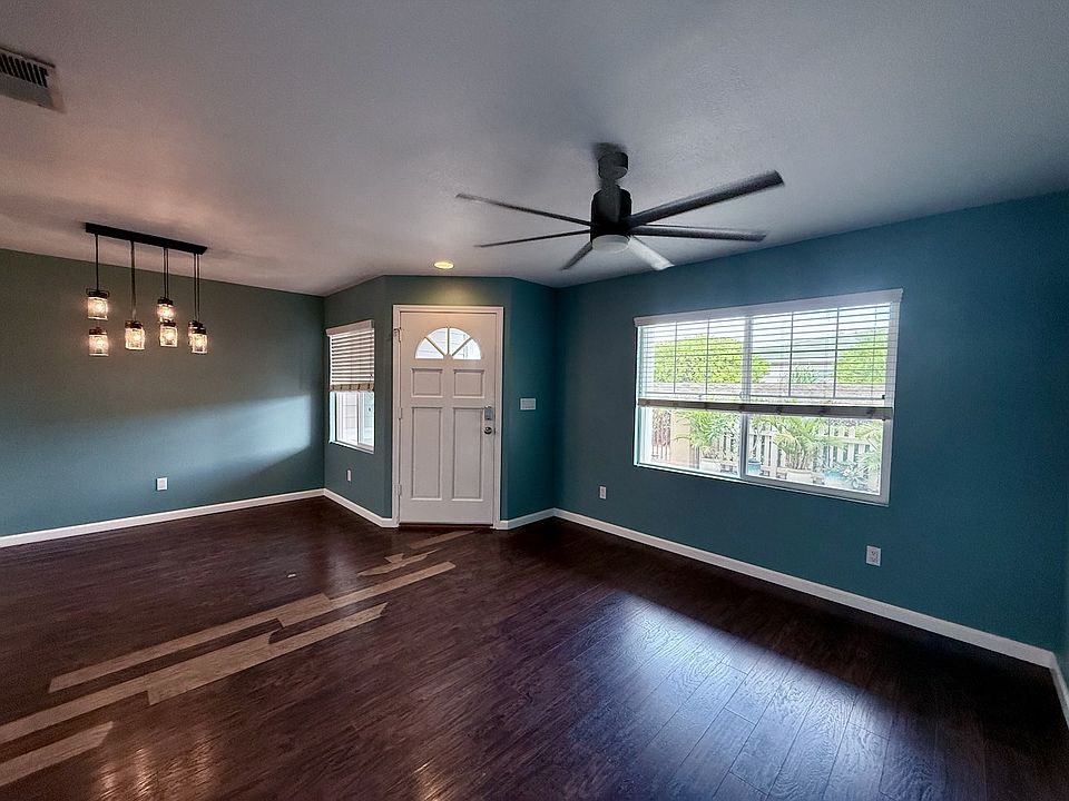 Spacious living area with central air conditioning and ceiling fan