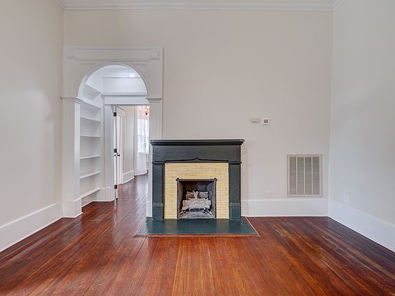 Living room and hallway bookshelves leading to primary bedroom.