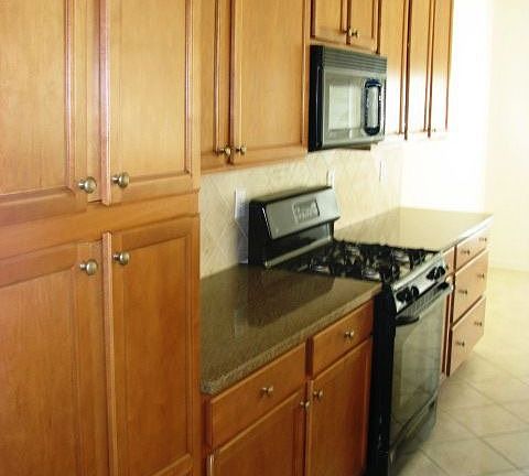 CUstom kitchen with Silestone counters,maple cabinets and black appliances