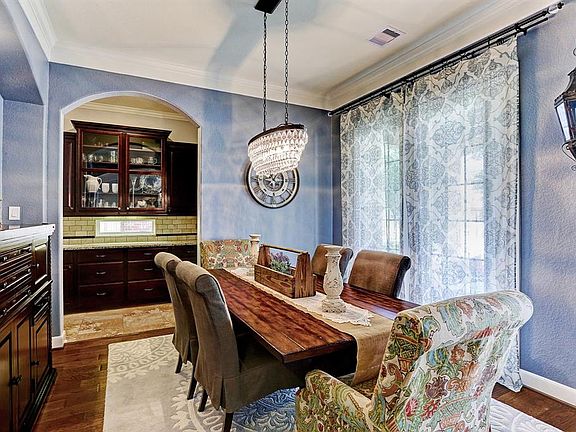Formal dining off the foyer with stunning chandelier is perfect for big family meals or dinner parties!