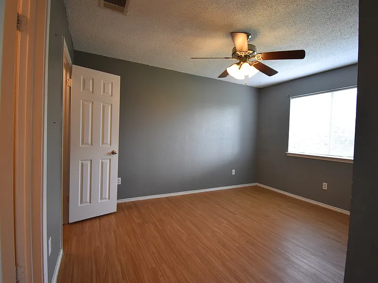 Primary bedroom on the second floor features a ceiling fan and a large window