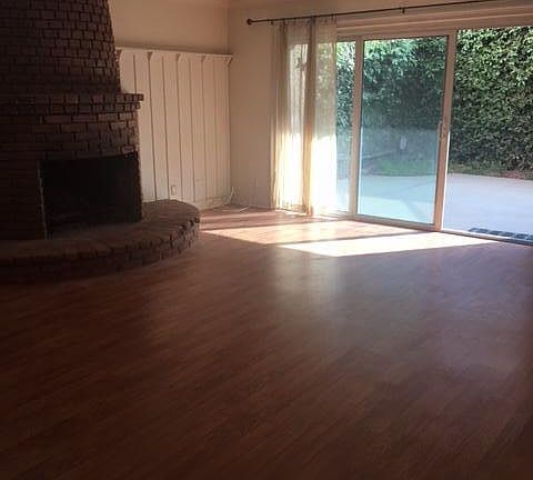 Living Room with Wood Burning Fireplace and Outdoor Patio
