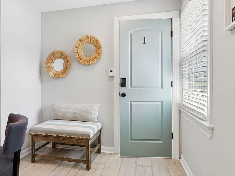 Welcoming entry area with a secure front door, window with blinds, and a bench for shoes and daily essentials.