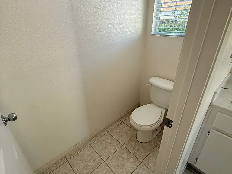Bathroom in primary room. Tub, shower, two sinks, separate room with toilet.