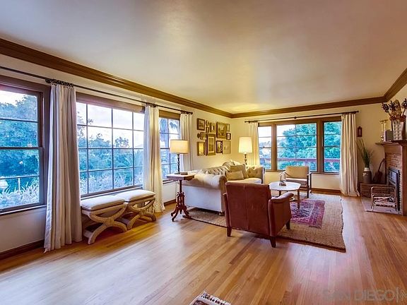 Windows wrap the classic living room and frames the trees beyond