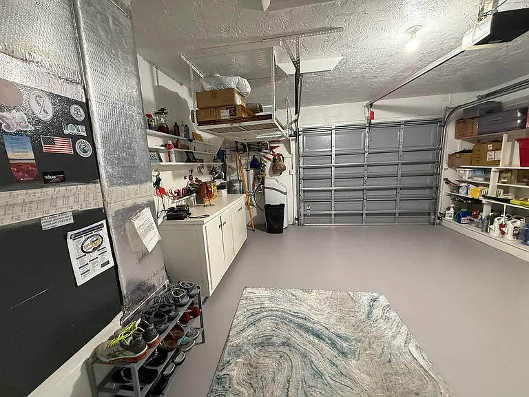 Wide garage with built in cabinetry snd tons of storage